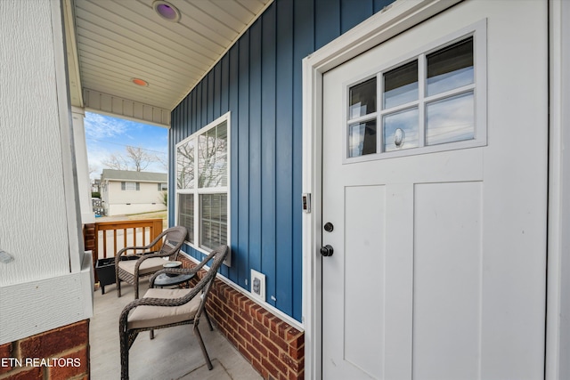 entrance to property featuring board and batten siding and covered porch