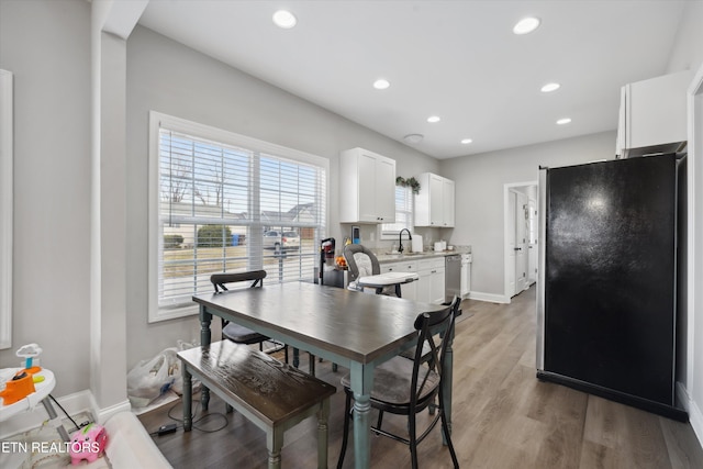 dining space featuring baseboards, wood finished floors, and recessed lighting