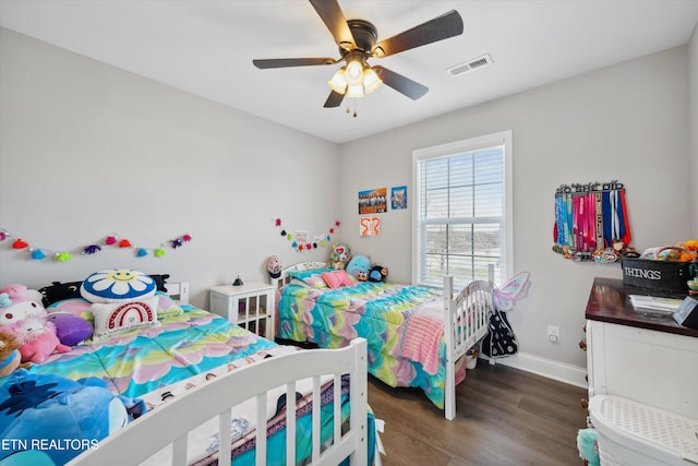 bedroom with a ceiling fan, dark wood-style flooring, visible vents, and baseboards