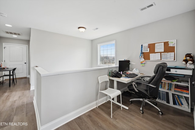 office with visible vents, baseboards, and wood finished floors