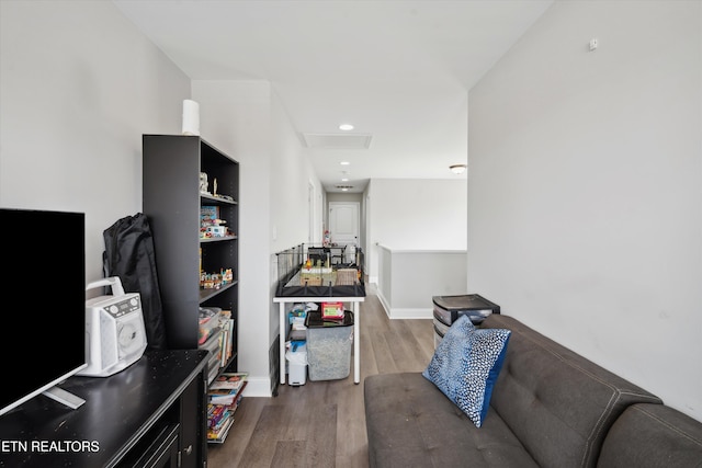 living room with attic access, baseboards, and wood finished floors