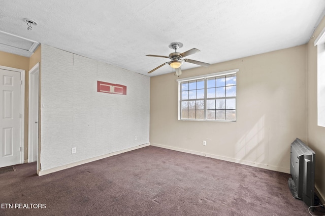 carpeted empty room featuring ceiling fan and a textured ceiling