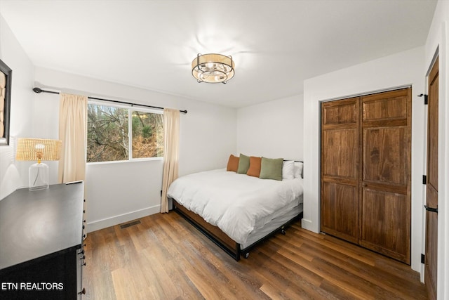 bedroom featuring baseboards, visible vents, and wood finished floors