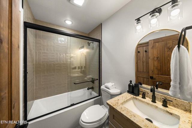 full bath featuring shower / bath combination with glass door, vanity, and toilet