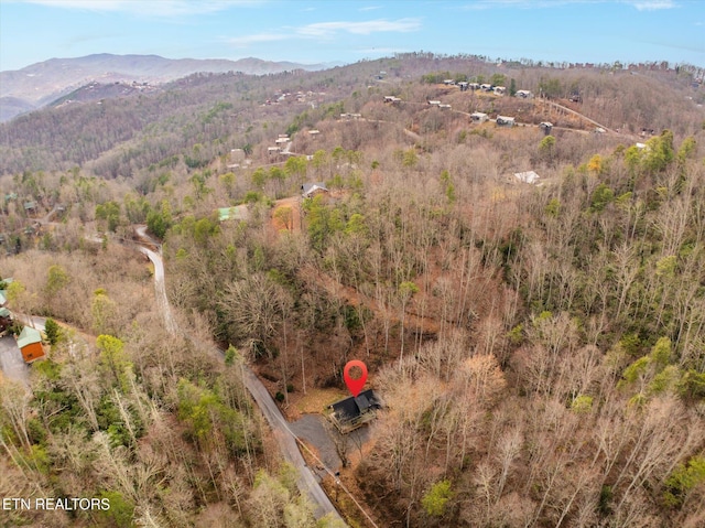 aerial view with a wooded view and a mountain view