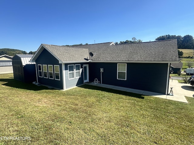 rear view of property with a lawn and a patio