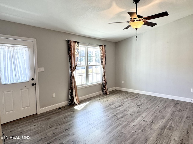 foyer with ceiling fan, light hardwood / wood-style flooring, and a textured ceiling