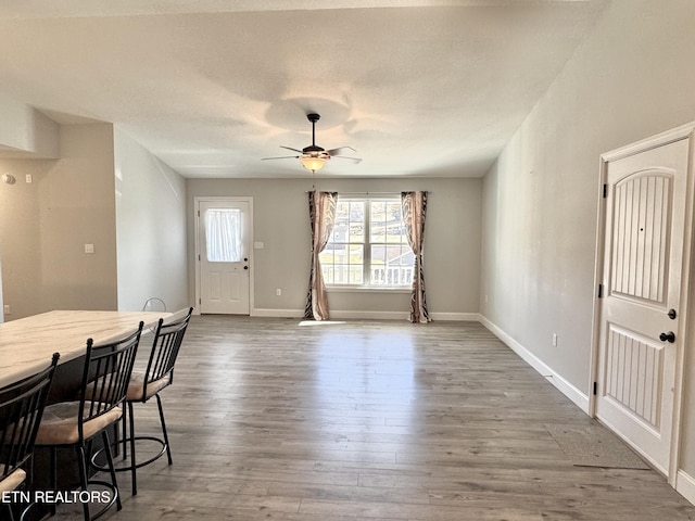 dining space with a textured ceiling, dark wood-type flooring, and ceiling fan