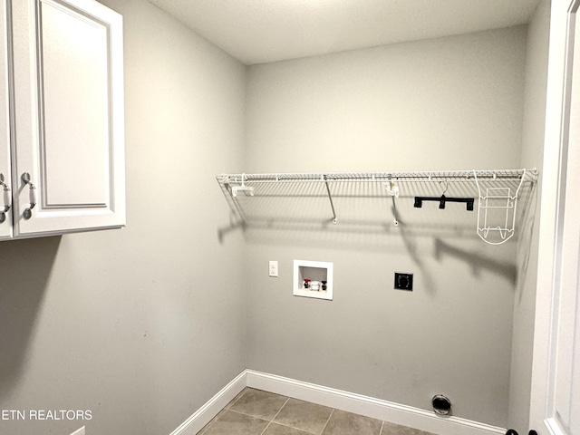 clothes washing area with cabinets, hookup for an electric dryer, hookup for a washing machine, and light tile patterned floors