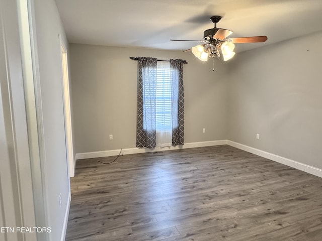 empty room with dark wood-type flooring and ceiling fan