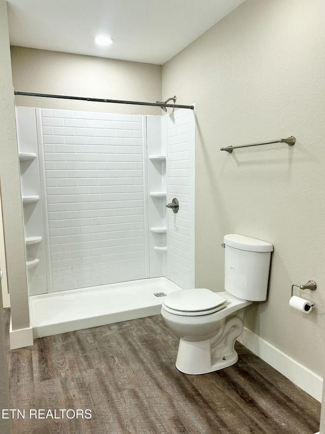 bathroom featuring toilet, hardwood / wood-style floors, and a shower