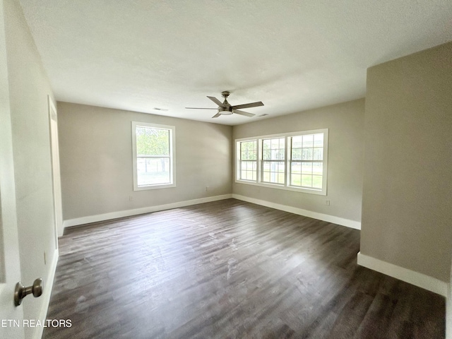 empty room with dark hardwood / wood-style flooring and ceiling fan