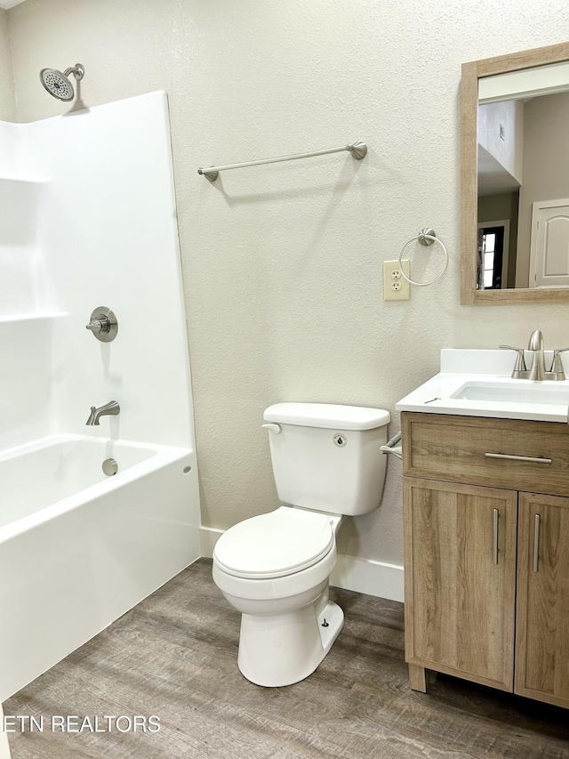 full bathroom with vanity, hardwood / wood-style flooring, shower / washtub combination, and toilet