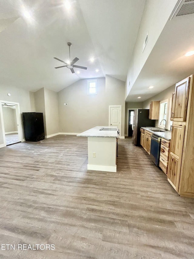 kitchen with lofted ceiling, sink, appliances with stainless steel finishes, a kitchen island with sink, and light hardwood / wood-style floors