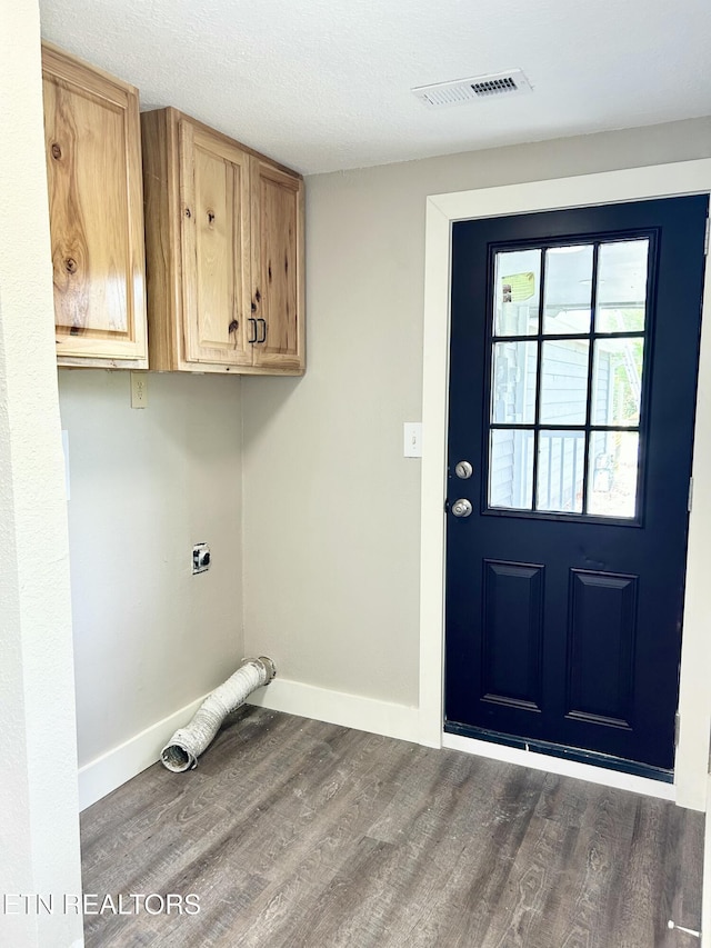 laundry room with hardwood / wood-style floors, cabinets, a textured ceiling, and hookup for an electric dryer