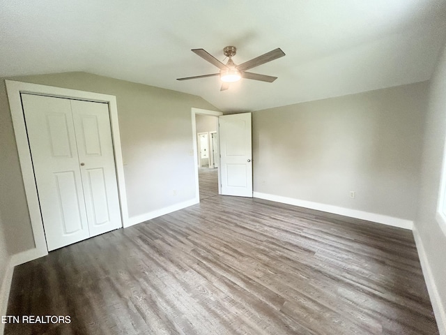 unfurnished bedroom with ceiling fan, lofted ceiling, wood-type flooring, and a closet