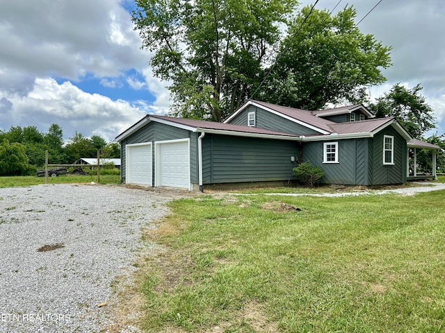 exterior space featuring a garage and a lawn