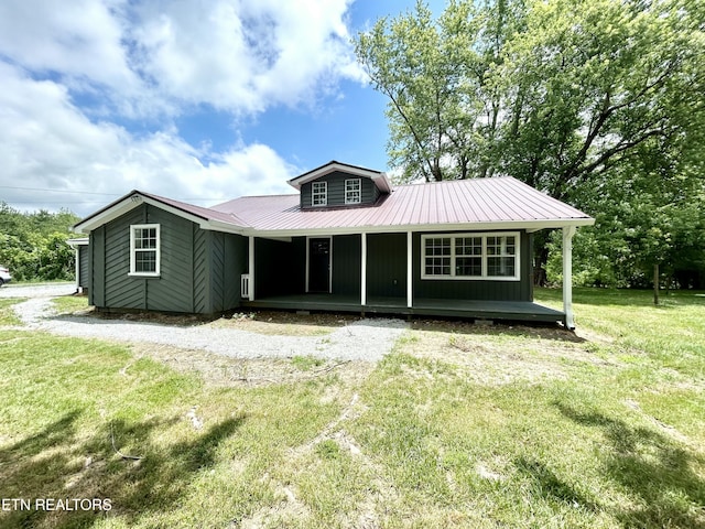 back of property featuring a yard and a porch