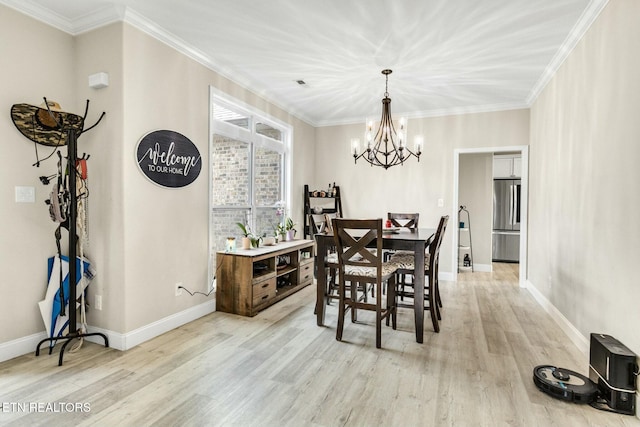 dining area with ornamental molding, a chandelier, and light hardwood / wood-style floors