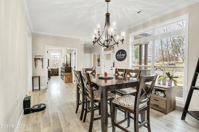 dining area with ornamental molding and light wood-type flooring