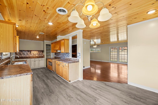 kitchen with hardwood / wood-style flooring, sink, hanging light fixtures, and backsplash