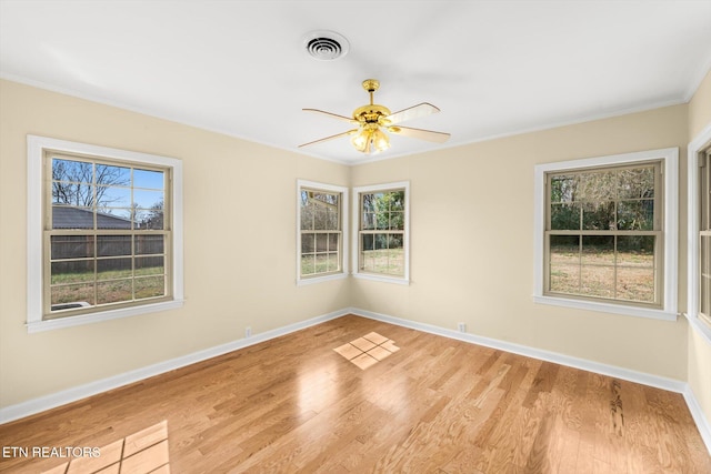 empty room with ceiling fan, ornamental molding, and light hardwood / wood-style flooring