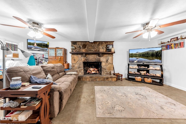 living room featuring ceiling fan, a fireplace, and beam ceiling