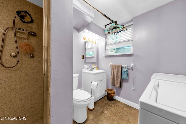 bathroom with a shower, vanity, toilet, tile patterned floors, and washer and clothes dryer