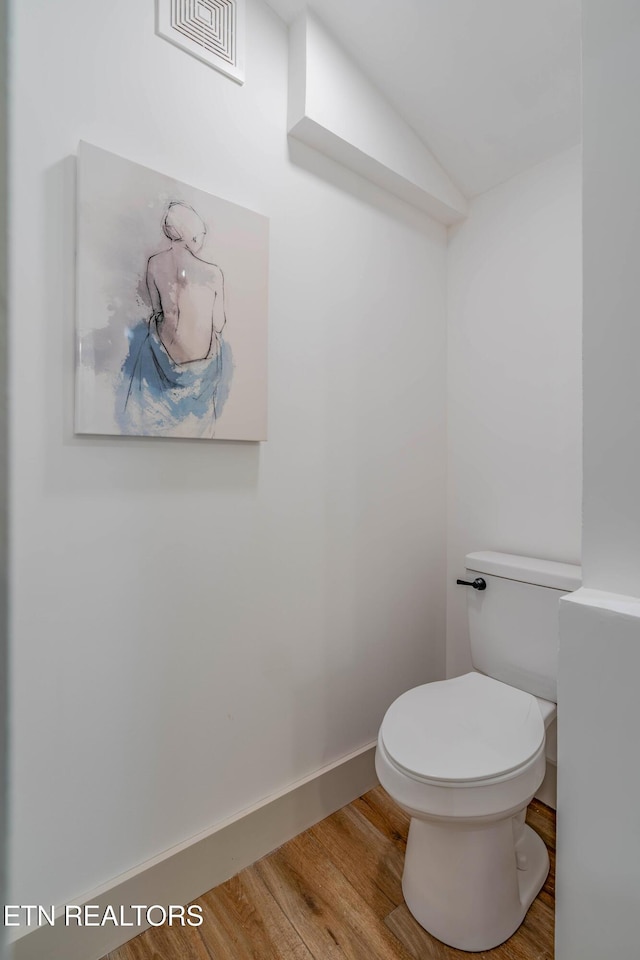 bathroom with hardwood / wood-style floors and toilet