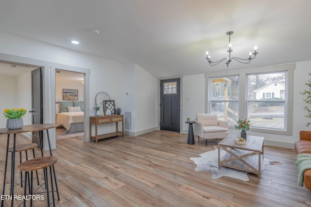 living room with an inviting chandelier and light hardwood / wood-style floors