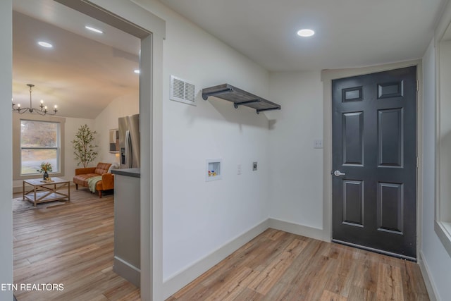 clothes washing area featuring electric dryer hookup, hookup for a washing machine, an inviting chandelier, and light wood-type flooring