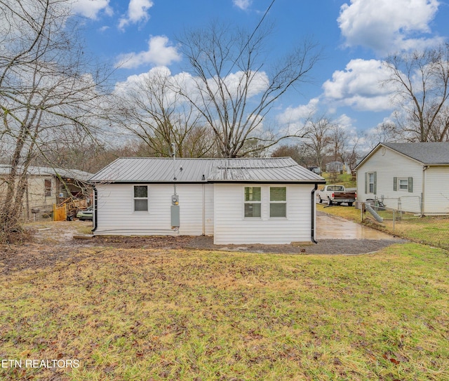 rear view of property with a lawn