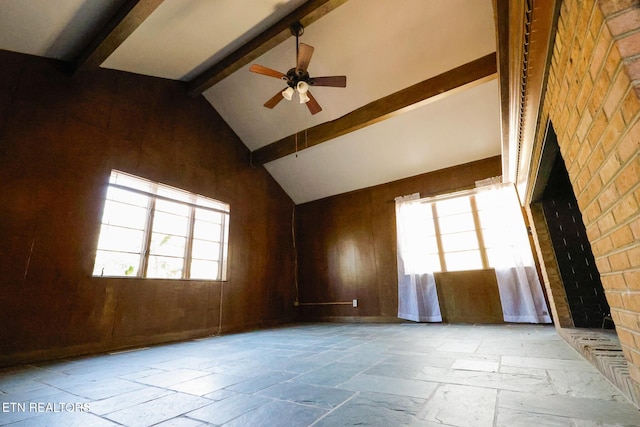 spare room with beamed ceiling, high vaulted ceiling, stone tile floors, and a ceiling fan