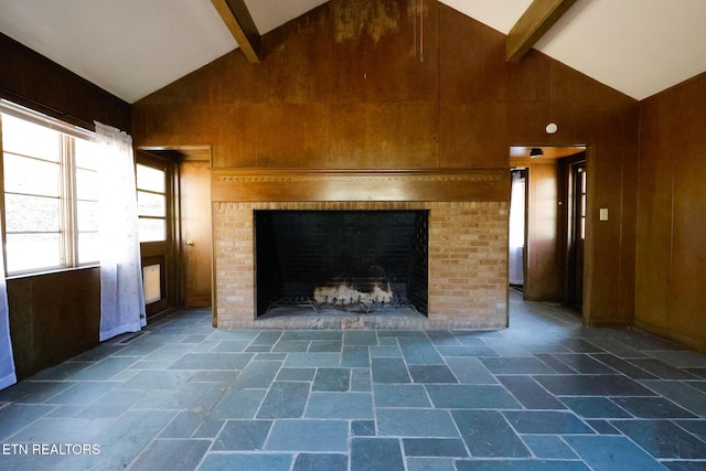 room details featuring beam ceiling, wood walls, and a fireplace