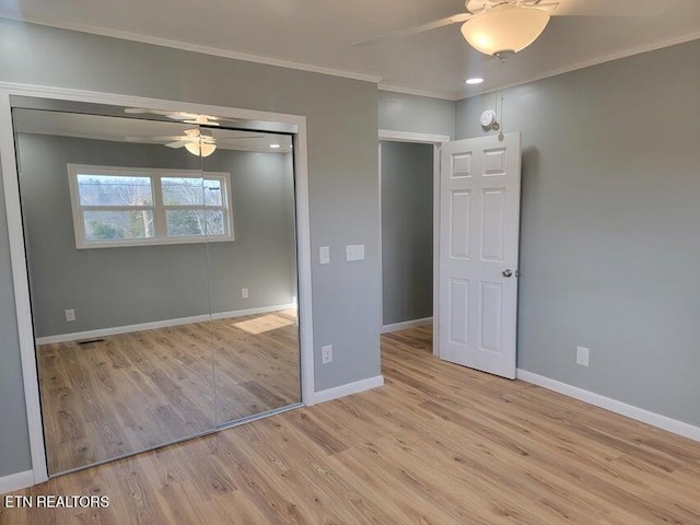 unfurnished bedroom featuring crown molding, ceiling fan, light hardwood / wood-style floors, and a closet