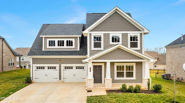 craftsman inspired home featuring a garage, covered porch, and a front lawn