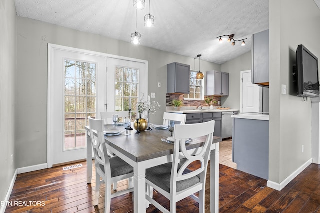 dining area featuring vaulted ceiling, dark hardwood / wood-style floors, and a textured ceiling