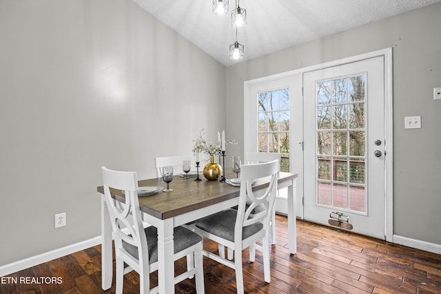 dining area featuring vaulted ceiling, dark hardwood / wood-style flooring, and a textured ceiling