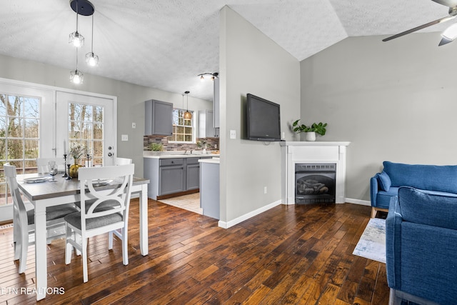 dining room with vaulted ceiling, dark hardwood / wood-style floors, and a textured ceiling