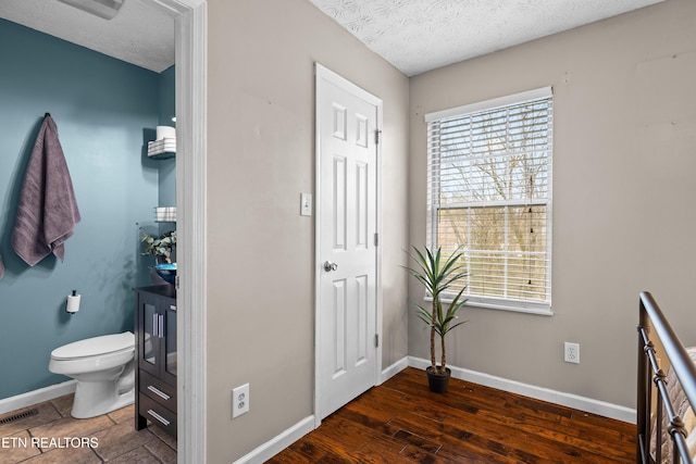 bathroom with plenty of natural light, wood-type flooring, and a textured ceiling