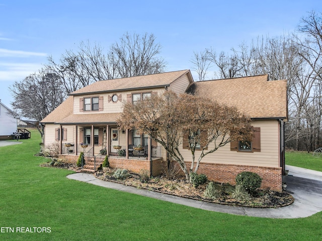 view of front of home with covered porch and a front lawn