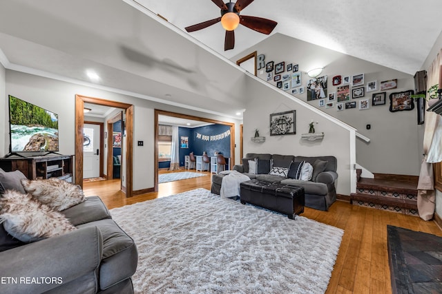 living room with crown molding, ceiling fan, and light wood-type flooring