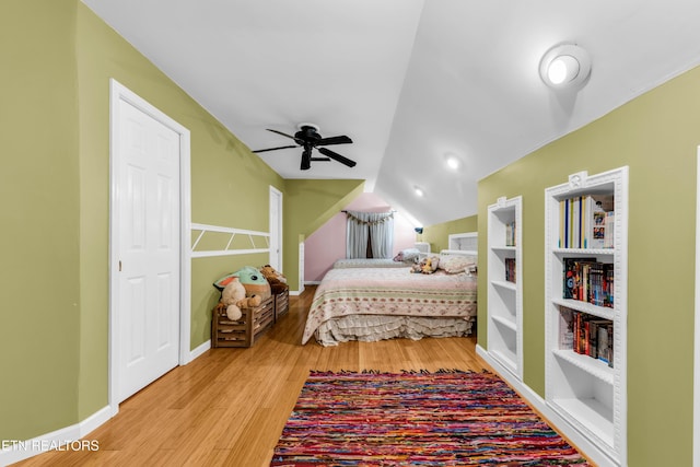 bedroom with ceiling fan, lofted ceiling, and light hardwood / wood-style floors