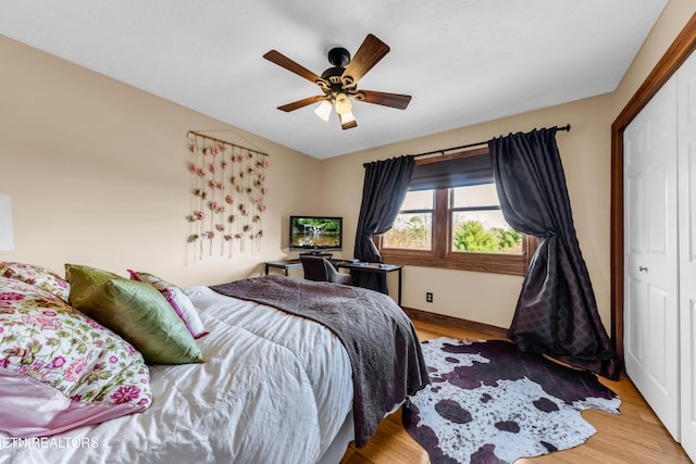 bedroom featuring ceiling fan, a closet, and light wood-type flooring