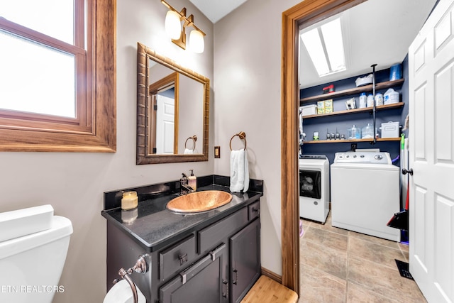 bathroom featuring vanity, independent washer and dryer, and toilet