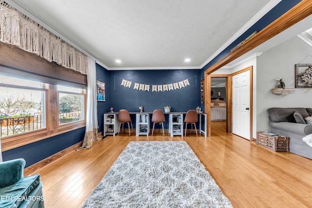 interior space with wood-type flooring, a textured ceiling, and crown molding