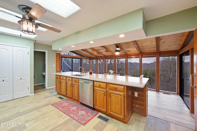 kitchen featuring sink, stainless steel dishwasher, a kitchen island with sink, ceiling fan, and light hardwood / wood-style floors