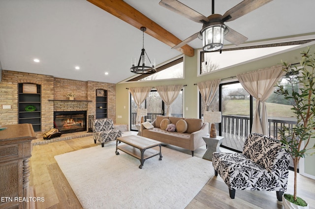 living room featuring light hardwood / wood-style flooring, high vaulted ceiling, a fireplace, built in shelves, and beamed ceiling