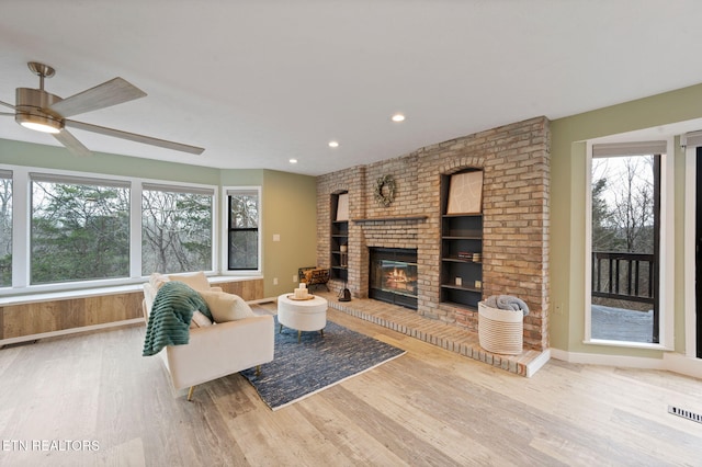 unfurnished living room with a fireplace, light hardwood / wood-style floors, and ceiling fan