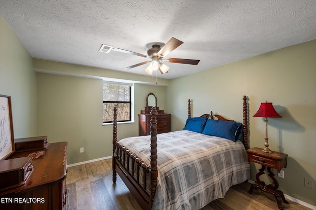 bedroom featuring ceiling fan, wood-type flooring, and a textured ceiling